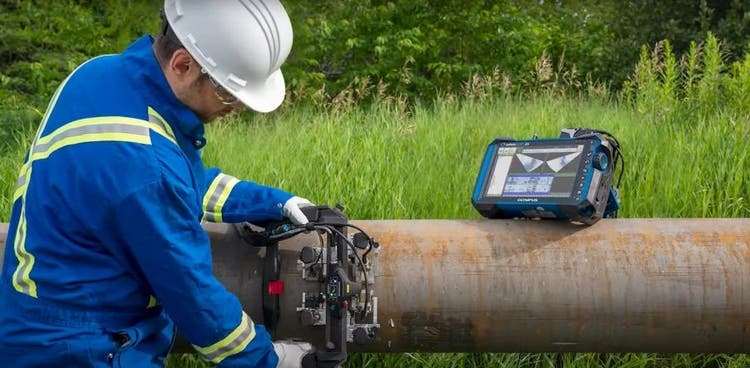 Technician performing phased array ultrasonic inspection on a pipeline long seam